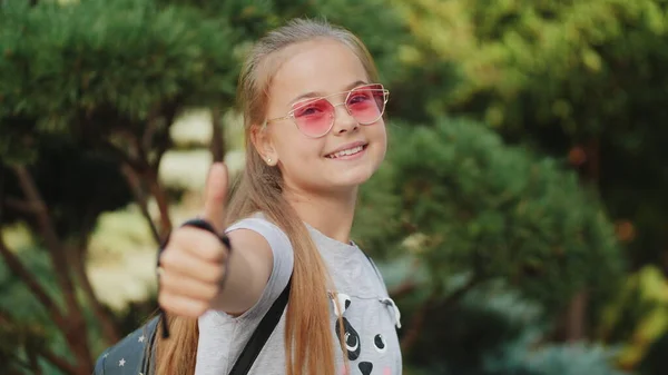 Feliz joven colegiala mostrando el pulgar hacia arriba — Foto de Stock