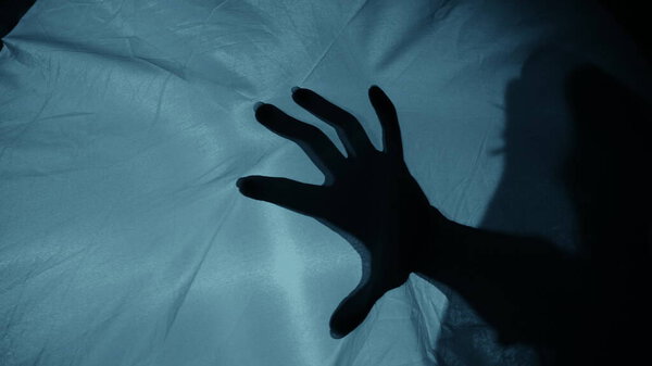 Силуэт: женская рука бьет по ткани, страх
