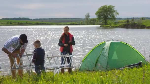 Gezin bij het meer, tent, klaptafel — Stockvideo