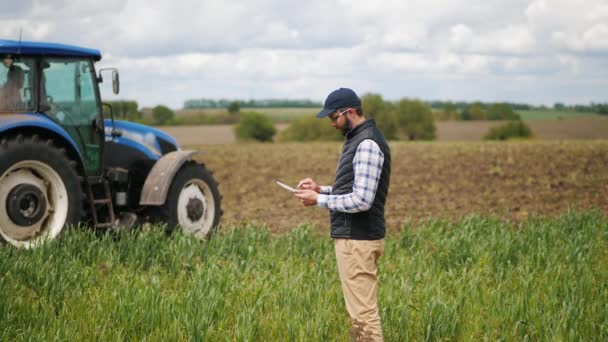 Agronomist használ egy speciális alkalmazás egy digitális tabletta területen — Stock videók