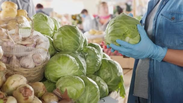 Una mujer con guantes compra repollo en el mercado, primer plano — Vídeo de stock