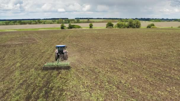 Jordbrukare på traktor med kultivator arbetar ute på fältet — Stockvideo