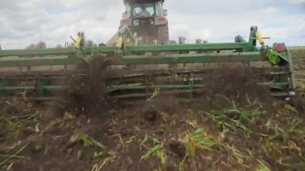 Un cultivateur sur un tracteur en travail sur le terrain, gros plan — Video