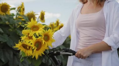 Sahada elinde bisikletle yürüyen bir kadın.