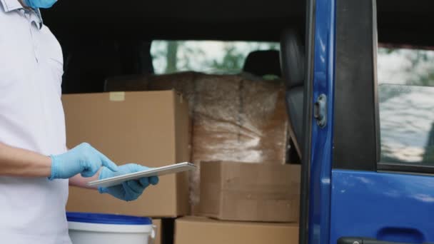 Leverancier met een tablet controleert zijn lading, close-up — Stockvideo