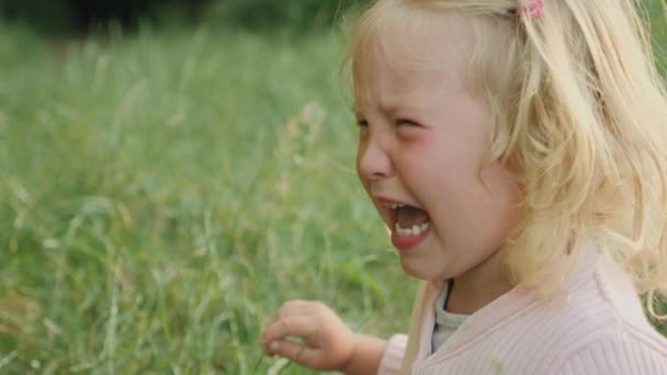 Triest blond meisje huilen met tranen in haar ogen in het park — Stockvideo