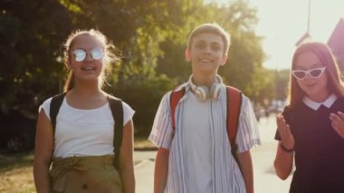 Sırt çantalı okul çocukları sokakta yürüyor.