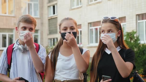 A diákok leveszik a védőmaszkokat az arcukról — Stock videók