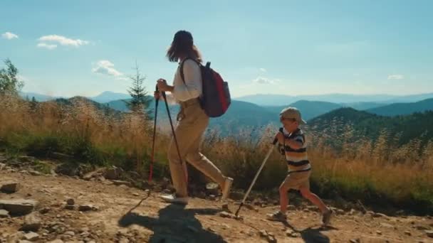 Genç, aktif bir anne ve küçük oğlu dağa tırmanıyor. — Stok video