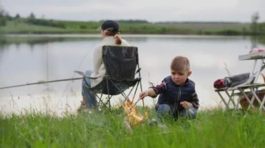 Küçük çocuk piknikte domuz pastırması kızartıyor.