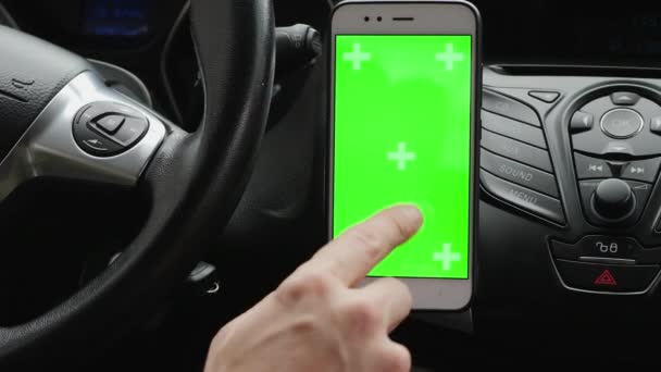 Uso de un teléfono inteligente de pantalla verde en el panel de control del coche — Vídeo de stock