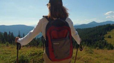 Gezgin dağın tepesindeki manzaranın tadını çıkarır.