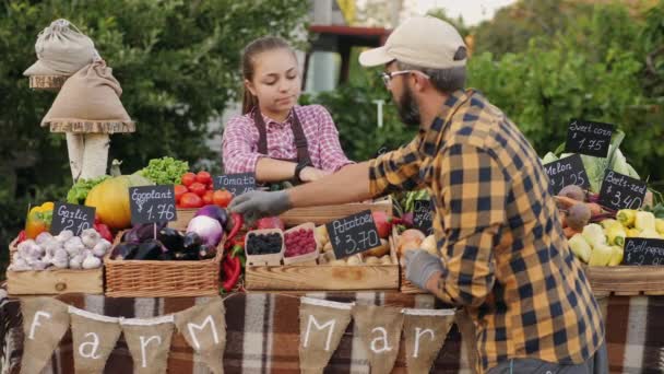 Baba ve kızı çiftçi pazarında çalışıyor. — Stok video