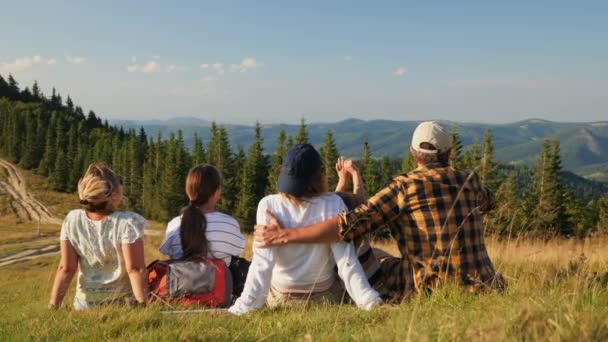 Сім'я мандрівників з дітьми насолоджується мальовничим видом на гори — стокове відео