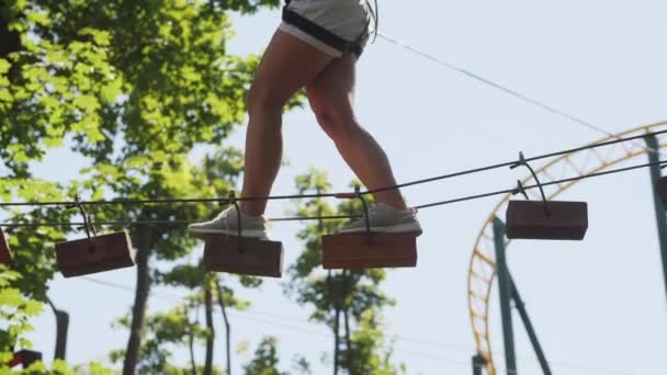 Ragazza che cammina su una corda in una città di corda, primo piano una gambe — Video Stock