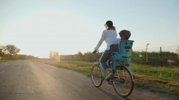 Mamma con il suo piccolo figlio stanno andando in bicicletta — Video Stock