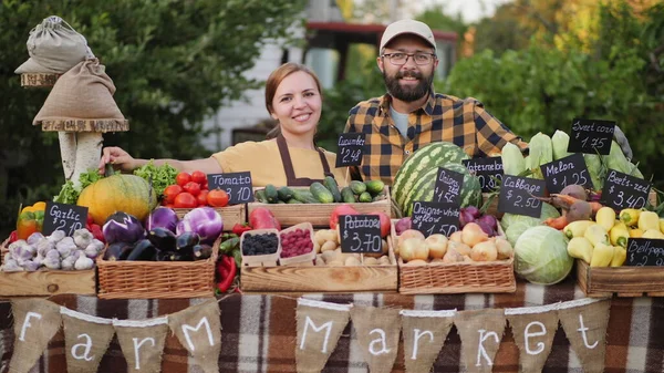 Casal jovem vendendo legumes e frutas locais de sua fazenda Imagens Royalty-Free