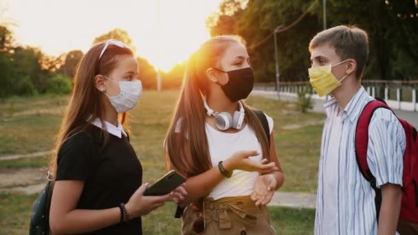 Kommunikation av tre tonåringar i skyddsmasker — Stockvideo