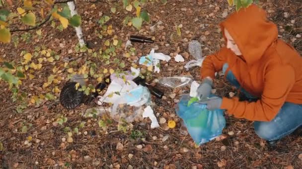 Mulheres coletam lixo em sacos na floresta — Vídeo de Stock