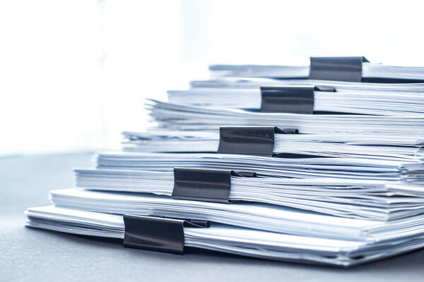 Стопки документов с черной застежкой.