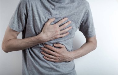 Mide ekşimesi kavramı. Bir erkek göğsüne tutunur. Yemek borusunda asit var.. 