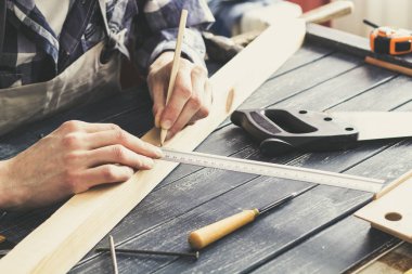 Marangoz ahşap kalaslarla bir atölyede çalışır.. 