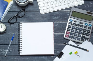 Finansal rapor için hesap makinesi, klavye ve gözlüklerle çalışma alanı. Masaüstü modern iş adamı. Muhasebe konsepti. Koyu arkaplan.