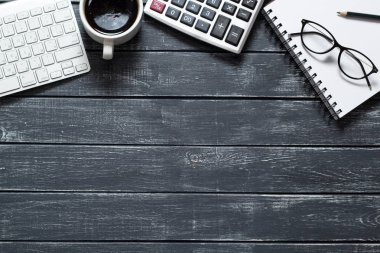 Finansal rapor için hesap makinesi, klavye ve gözlüklerle çalışma alanı. Masaüstü modern iş adamı. Muhasebe konsepti. Koyu arkaplan.
