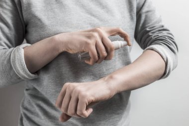 Bir kadın bir sivrisinek kovucu kullanır. Çeşitli böcekler sprey. 