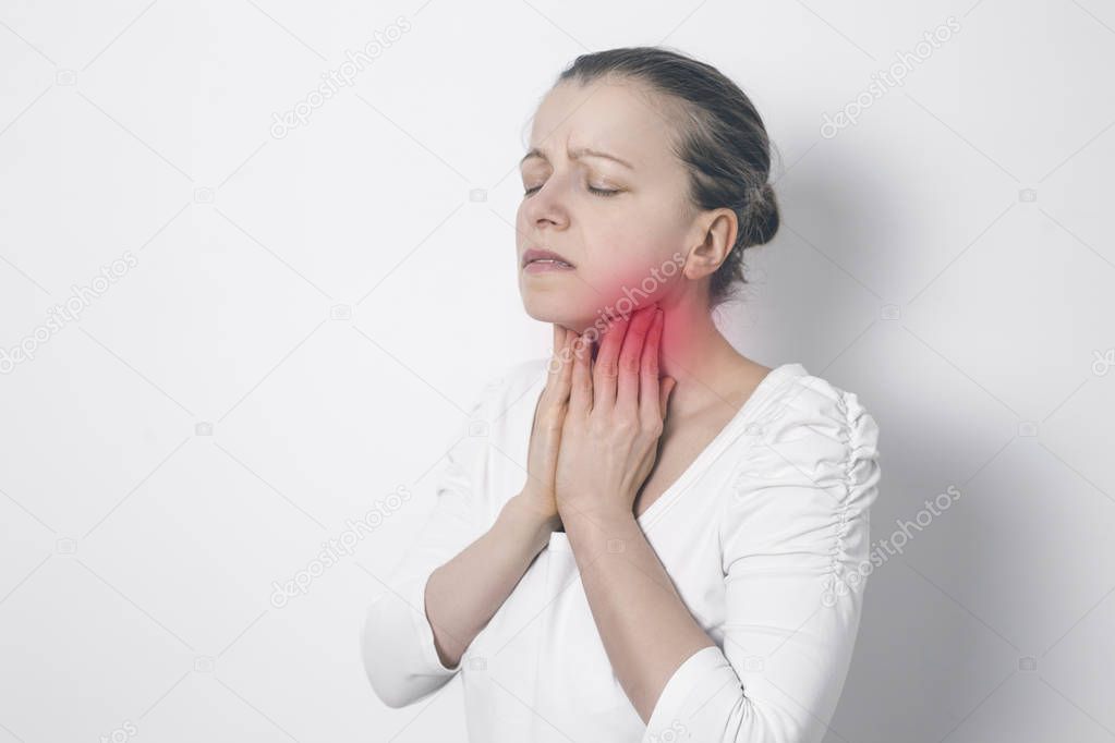 Angina. A woman holding her sore throat. Inflamed thyroid gland.