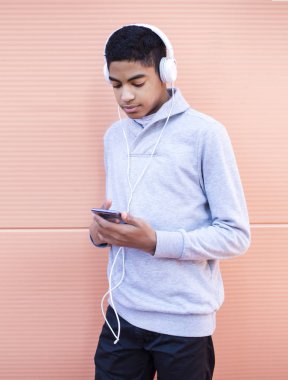 Kulaklıkta genç adam bir akıllı telefonda müzik dinliyor. Bir cep telefonu üzerinde oyun oynayan Afrikalı Amerikalı adam.