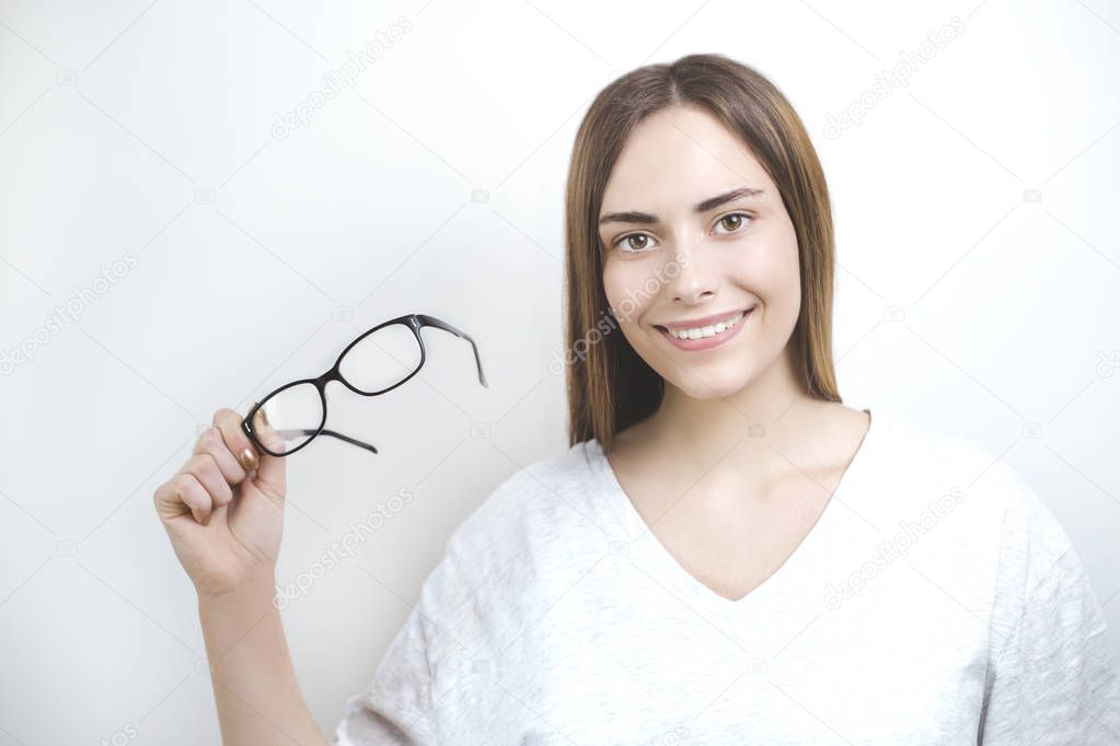 Happy smiling woman holding glasses on white background. Optics for sight. 