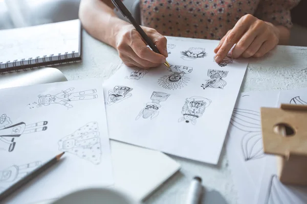 stock image Animator designer draws sketches of various characters. Creating illustrations on paper for cartoons or video games.