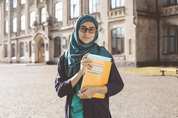 Joven Estudiante Musulmana Sonriente Sosteniendo Libros Cerca Universidad Chica Árabe —  Fotos de Stock