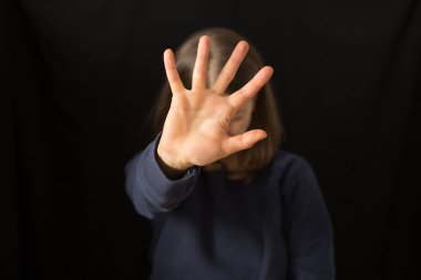 Ağlayan bir kadın siyah bir arka planda eli ile yüzünü kapatır. Aile içi şiddet kavramı. 