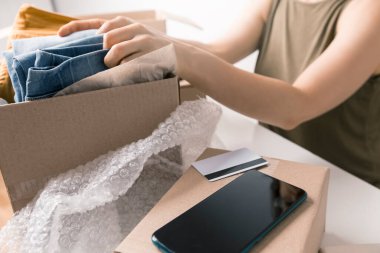 Kadının internetten sipariş ettiği kutular dolusu mal kredi kartıyla ödenmiş. Eve teslim.