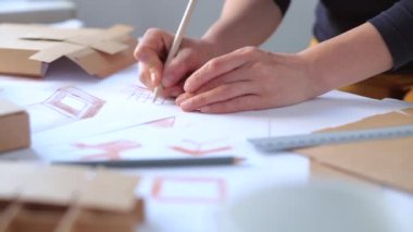 Tasarımcı karton kutu yapmak için bir maket çizer. Kağıt ambalajının bir taslağını oluştur.