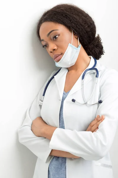 Portret Afroamerykanki Białym Płaszczu Smutna Pielęgniarka Masce Stoi Przy Ścianie — Zdjęcie stockowe