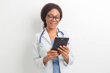 İş için elinde tablet tutan Afrikalı Amerikalı bir kadın doktorun portresi. Siyah hemşire dijital bir ortam kullanıyor..