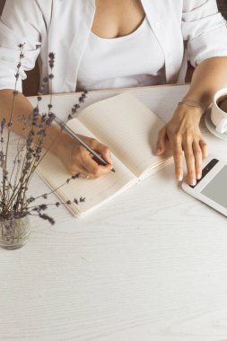 Ders kitabına yazı yazan bir kadın.