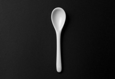 Siyah arkaplanda beyaz kaşığın üst görünümü