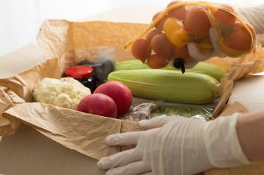 Gönüllülerden insanlara karton kutuda bağışlanan yiyecekler..