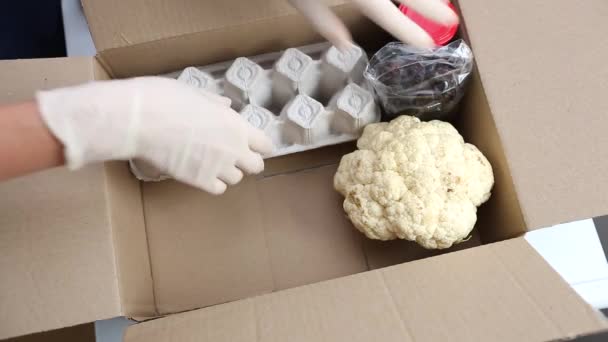 女性ボランティアが食べ物を箱に入れる 食料品の宅配便 困っている人を助ける — ストック動画