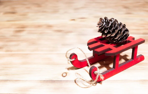 Праздничные дни, подарки, новый год и праздничная концепция - замыкание подарочных коробок с пустой запиской на красных деревянных санях на фоне рождественской елки и огней — стоковое фото