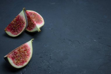 Taze incir dilimler halinde kesin. incir portre siyah beton üzerinde. metin için yer. Diyet fruit.fesh