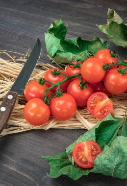 kiraz domates yaprakları ahşap ve saman ile ahşap bir yüzeye.