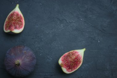 Taze incir. Gıda Fotoğrafçılık. Bütün ve dilimlenmiş incir bir dikdörtgen içinde yazıtlı karanlık bir arka plan üzerinde yaratıcı şeması. Kopya alanı