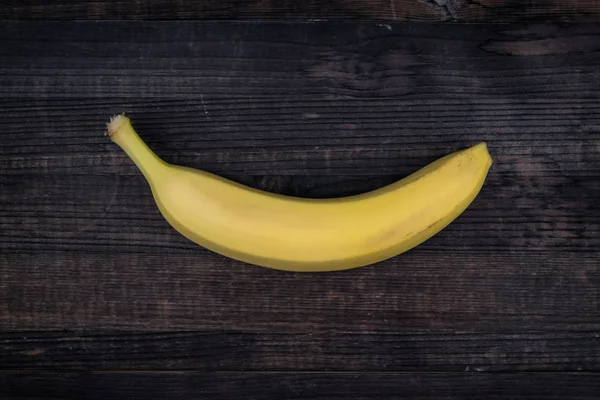 One mature banana isolated on a wooden background. banana