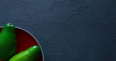 Bütün avokado el yapımı tabak içinde yatıyor. Sağlıklı yeme meyve ve sebze kavramı. yukarıdan görüntüleyin. metin için yer. kopya alanı