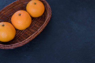 Mandalina sepet, karanlık bir arka plan üzerinde Noel dekor içinde. Tatil kavramı. Yukarıdan görüntüleyin. Karanlık rustik tarzı. metnin altında boşluk.